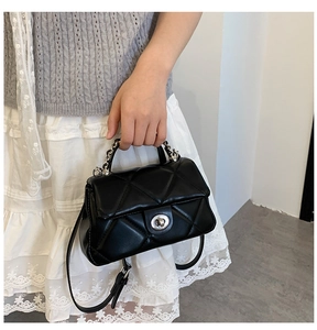 Chic quilted crossbody bag with silver twist lock and chain handle shown in use