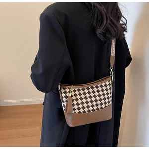 Close-up of retro bucket bag with diamond weave pattern and wide ethnic strap