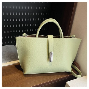 Detail view of pistachio green lychee pattern leather bag with metallic twist lock