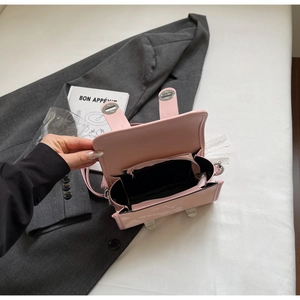 Detail view of pink patent leather bag interior with zipper pocket and silver hardware