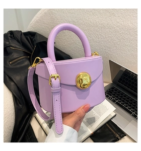 Detail of lavender leather handbag with a large gold buckle and elegant top handle