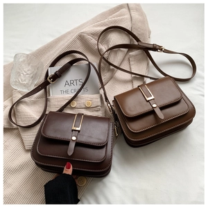 Detail of vintage square crossbody bags in dark coffee and caramel with gold metal trim