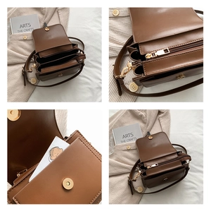 Detail view of brown leather crossbody bag showing inner compartments and gold hardware