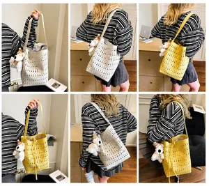 Detail view of hollow out bucket bag with laser cut pattern and plush puppy charm