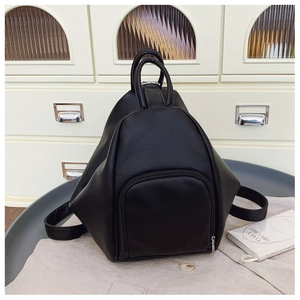 Detail of black lychee grain leather texture and silver zipper on multifunctional backpack