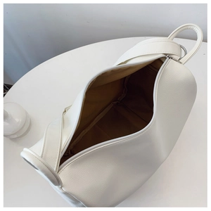 Top view of white pebble leather cylinder bag showing spacious interior and handles