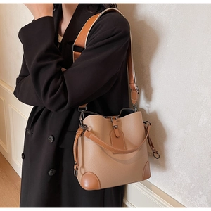 Detail der braunen Vintage-Beuteltasche mit breitem Stoffgurt und genarbter Lederstruktur