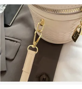 Close-up of golden metal buckle and woven leather detail on the stylish bucket bag