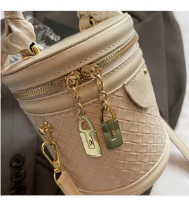 Detail of woven leather texture on a bucket bag with smooth golden zippers and silk scarf