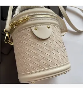 Detailed view of beige woven bucket bag showing intricate leather weaving and gold metal zipper