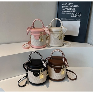 Detail of four woven leather bucket bags in pink, white, black, and brown with silk scarves
