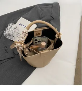 Dettaglio borsa a secchiello beige con spazio interno per smartphone e cosmetici
