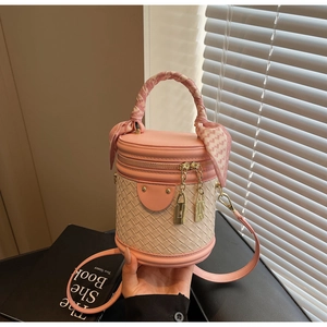 Detailed close-up of pink and beige patchwork bucket bag with woven texture and silk scarf