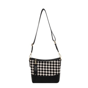 Checkerboard bucket bag with black leather base, wide strap and tassel charm