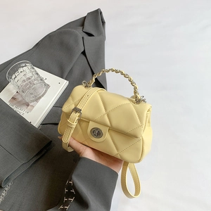Pale yellow quilted handbag with classic diamond pattern and silver metal twist lock closure