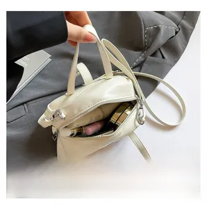 Top view of white shell bag showing interior capacity with lipstick and makeup items