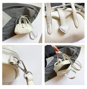 Detailed view of cream PU leather handbag featuring heart buckle and silver hardware