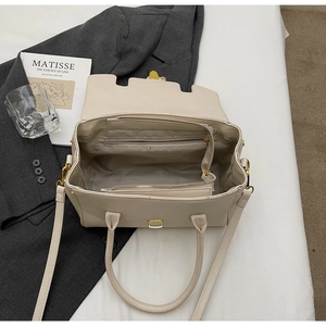 Detailed interior view of beige briefcase showing multiple compartments and golden zippers
