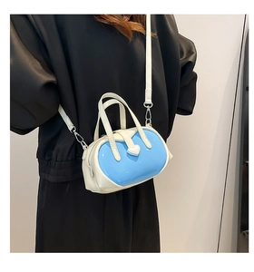 Detail of blue and white mini crossbody bag with heart buckle on black clothing