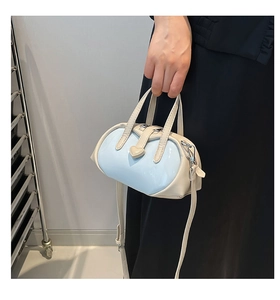 Detail of blue and white heart boston bag showing dual handles and leather texture
