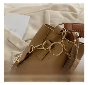 Close-up of brown bucket bag showing gold hardware and cute bunny plush charm detail