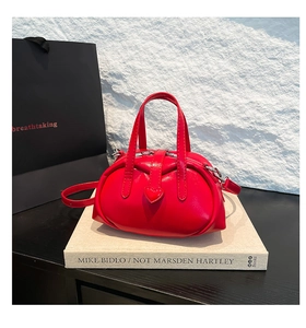 Close-up of shiny red heart-shaped bowling bag featuring a glossy patent leather finish
