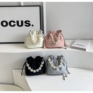 Modern bucket bags with large pearl handles and chain straps in four neutral colors