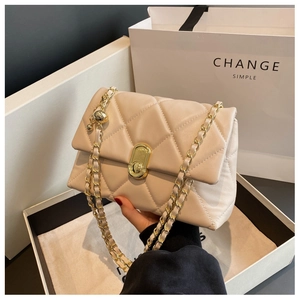 Detail of beige quilted leather bag with gold chain strap and rotary lock hardware