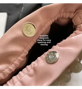 Detail of pink pleated bag showing the hidden magnetic clasp for easy opening