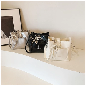 Three crocodile texture crossbody bags with pearl bows and heart charms in a row