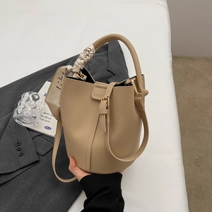 Secchiello chic in pelle beige con foulard di seta sul manico e tracolla lunga
