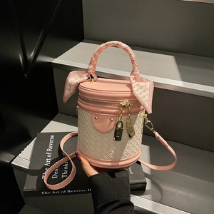 Chic pink and beige woven leather bucket bag with silk scarf handle on steps