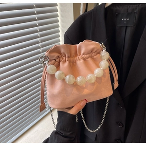 Detailed shot of pink pleated bucket bag with marble bead handle and silver chain strap