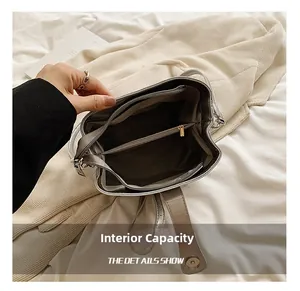 Detail view of silver bucket bag interior with multiple compartments and dark grey lining