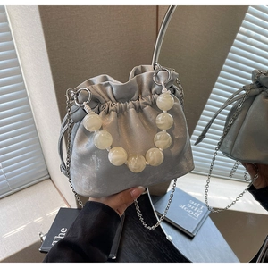 Silver satin bucket bag with marble bead handle and metallic chain strap detail
