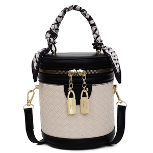 Front view of a black and beige patchwork bucket bag with woven texture and scarf handle