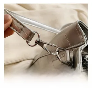 Close-up of durable metal hook and silver textured leather strap on a bucket bag