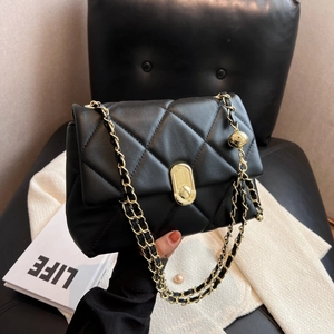Classic black quilted leather crossbody bag with elegant gold chain and spherical ornament