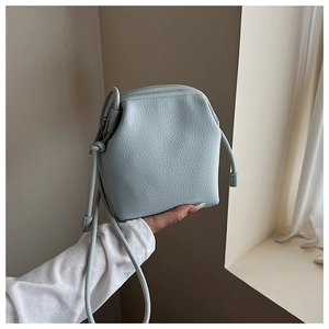Detail of light blue crossbody bag with lychee texture and slim drawstring strap