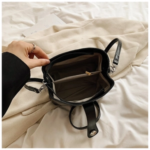 Detail view of the black crossbody bag's dual-compartment interior and metal zipper