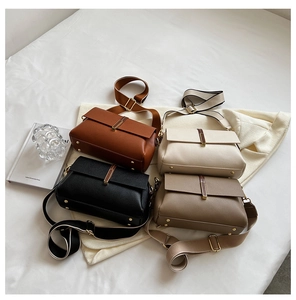 Detail view of four crossbody bags in leather texture with wide canvas straps and gold buckles