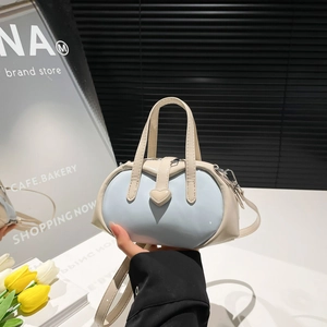Minimalist light blue and beige shell-shaped handbag with heart-shaped buckle and crossbody strap