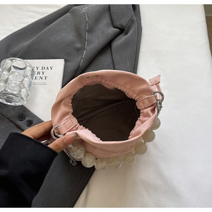 Top view of pink bucket bag interior with large white bead accents and drawstring design