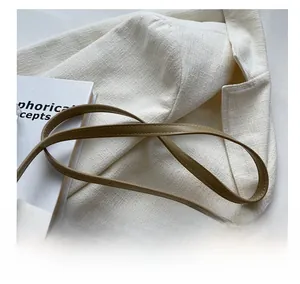 Detail shot of the khaki leather shoulder strap with precise stitching on a baguette bag