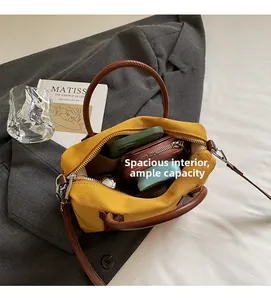 Vue intérieure du sac Boston en toile jaune montrant un compartiment spacieux avec objets