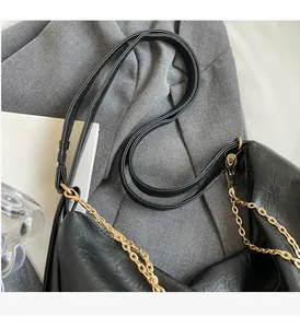Close-up of durable black faux leather tote bag with elegant gold metal chain detail