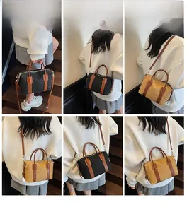 Détail du sac Boston vintage montrant les poignées en cuir et les crochets en métal