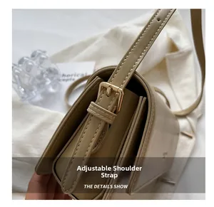 Detail of adjustable shoulder strap with gold buckle on khaki leather baguette bag