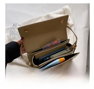 Detailed interior of khaki crossbody bag showing three compartments and magnetic closure