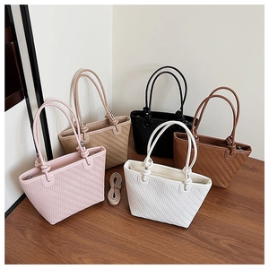 Gros plan détaillé sur la texture tressée des sacs à main en rose beige noir et marron